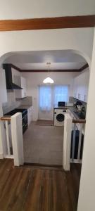 cocina con encimeras blancas y fogones en Waddon lodge, en Croydon