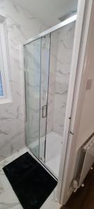 una ducha con puerta de cristal en un baño en Waddon lodge, en Croydon