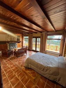 a bedroom with a large bed and a fireplace at La Margarita in El Bolsón