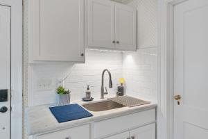 une cuisine avec des armoires blanches et un évier dans l'établissement The Cottage at Knollwood Manor, à Southern Pines 36 autres photos