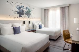 a hotel room with two beds and a desk at Archer Hotel Old Town Alexandria in Alexandria +52 photos