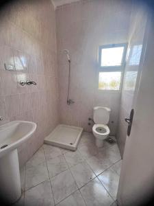 a bathroom with a toilet and a sink at قرية دعاء السماء in El Hamam