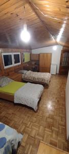 a room with three beds and a wooden floor at Adam room piwnica in Wrocław