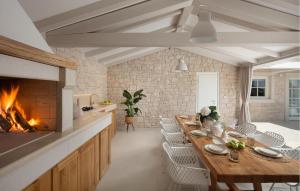 une salle à manger avec une cheminée et une longue table dans l'établissement Villa Gabriel Residence, à Žminj