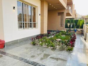 a house with a garden on the side of it at اكتوبر الشيخ زايد بجوار مول العرب in Sheikh Zayed +3 photos