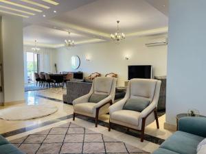 a living room with chairs and a dining room at اكتوبر الشيخ زايد بجوار مول العرب in Sheikh Zayed