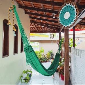 a green hammock in a room with plants at Pousada Pedra das Amazonas in Parintins