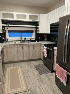 a kitchen with white cabinets and a black refrigerator at Crystal's Place in Moncton