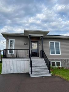 a house with a porch and stairs in front of it at Crystal's Place in Moncton