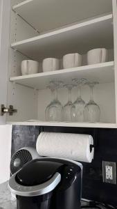 a bathroom with a toilet and glasses on shelves at Crystal's Place in Moncton +43 photos