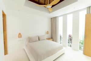 a white bedroom with a bed and a window at Sonnys Uluwatu in Uluwatu +38 photos