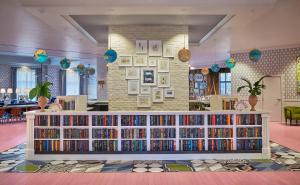a library with a large book shelf filled with books at Graduate by Hilton Oxford in Oxford