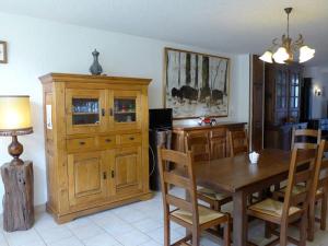 ein Esszimmer mit einem Tisch und einem Holzschrank in der Unterkunft Maison avec Piscine Privée Chauffée, Cheminée et Activités à Goncourt - FR-1-611-106 in Goncourt