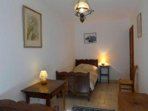 ein Schlafzimmer mit einem Bett und einem Tisch in einem Zimmer in der Unterkunft Maison avec Piscine Privée Chauffée, Cheminée et Activités à Goncourt - FR-1-611-106 in Goncourt