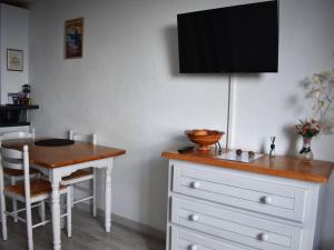 Il comprend une cuisine avec une table et une télévision murale. dans l'établissement Studio Cabine 4 Pers. - Exposé Plein Sud - FR-1-580-117, à Font-Romeu-Odeillo-Via
