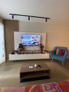 a living room with a couch and a tv at DEPARTAMENTO KILLA HUATANA in Cusco