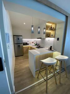 a kitchen with a counter and two stools in it at DEPARTAMENTO KILLA HUATANA in Cusco +24 photos