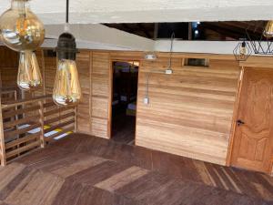 a room with wooden walls and lights and a wooden floor at Petra Hotel in Nuquí