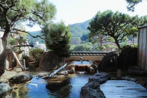 un laghetto in un giardino con ponte di legno di Wakamatsu HakoneYugawara a Yugawara