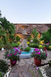 a fountain in the middle of a garden with flowers at Hotel Boutique Adela in Granada