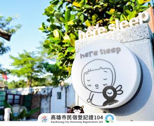 un cartello sul lato di un edificio di Here Sleep Guesthouse a Kaohsiung