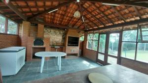 a large room with a table and a stove at Casa da Felicidade in Ibiúna