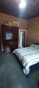 a bedroom with a bed and a dresser in it at Casa da Felicidade in Ibiúna