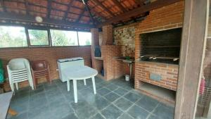 a patio with a brick fireplace and a table and chairs at Casa da Felicidade in Ibiúna