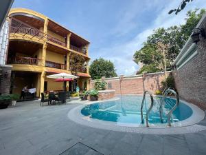 a swimming pool in front of a building at Maison Duyên in Hue