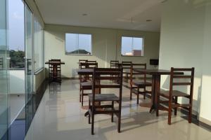 a dining room with tables and chairs and windows at Hotel Vilamoura in São Paulo