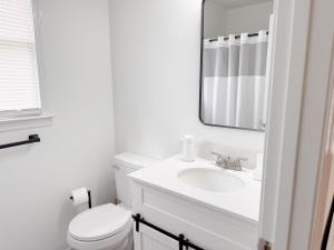 a white bathroom with a sink and a mirror at Aesthetic Home Near Ft Campbell in Clarksville +13 photos