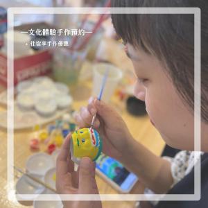 a young girl is holding a toy with a knife at Wuzou Guesthouse in Jinsha