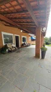 an outdoor patio with chairs and a brick building at Casa da Felicidade in Ibiúna