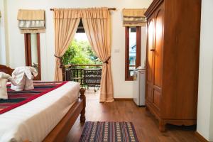 ein Schlafzimmer mit einem Bett und einem Fenster in der Unterkunft Gordnuea Boutique House in Chiang Mai