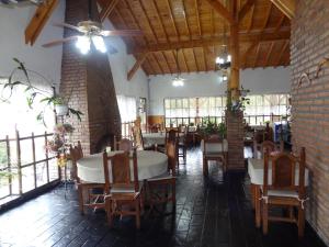 a dining room with tables and chairs and windows at Hostería Lida in Merlo
