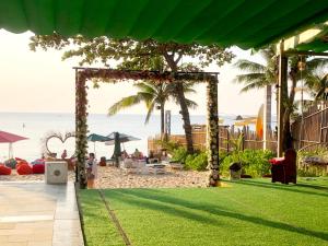 a garden with an arch on the beach at BB Hotel&Resort in Phu Quoc
