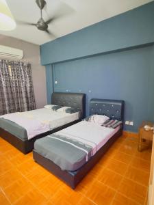 2 letti in una camera con parete blu di SEAVIEW 2 BEDROOMS APARTMENT BAYU BEACH RESoRT PD a Port Dickson