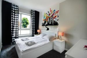een slaapkamer met een wit bed en een raam bij JTB Nautica Aparthotel in Szczecin