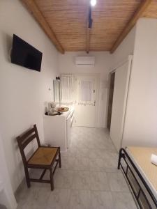 a kitchen with a chair and a white refrigerator at Miltiadis Apartments in Ambelas
