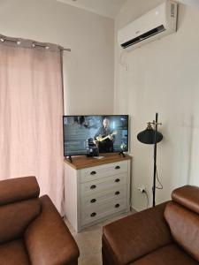 ein Wohnzimmer mit einem Flachbild-TV auf einer Kommode in der Unterkunft VanjAna 2 in Ðenovići