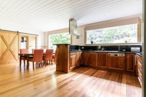 a kitchen with a table and a dining room at Riverwood Cottage, accessible accommodation in Warburton