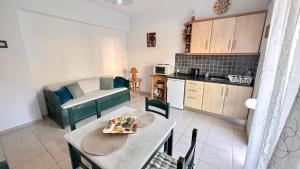 a kitchen and a living room with a table and chairs at Afandou Blue Apartment in Afantou