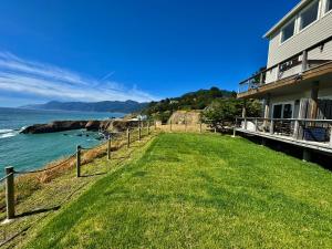 una casa con un prato verde vicino all'oceano di Magnificent Oceanview by OceanviewHotTubs Oceanfront! Shelter Cove, CA Tesla EV station a Shelter Cove