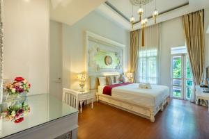 a bedroom with a bed and a desk with flowers at SHIN Hotel Chiangmai Gate in Chiang Mai