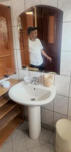 阿斯马拉Guest House in Asmera的画浴室水槽的人