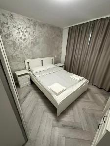 une chambre avec un lit blanc et un parquet dans l'établissement Davinci Apartment, à Sibiu