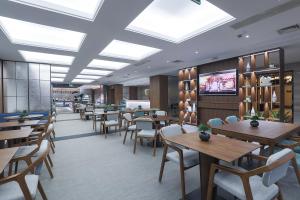 杭州杭州东站汇和君亭酒店 - 免费自助洗衣的有桌椅和电视的餐厅