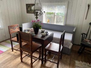 a dining room with a table and chairs and a table and a window at 4 person holiday home in NYKVARN in Nykvarn