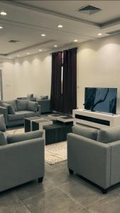 un salon avec des canapés et une télévision à écran plat dans l'établissement The Private chalet للعائلات فقط, à Al Khiran
