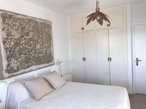 a bedroom with a bed and a painting on the wall at Mirando al Mar con Wifi y Terraza 1ª línea playa in Cádiz